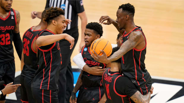 Houston ‘s Taze Moore, top right, is hoisted by Kyler Edwards (11) as they celebrate a 68-53 win over Illinois in a college basketball game in the second round of the NCAA tournament in Pittsburgh, Sunday, March 20, 2022.